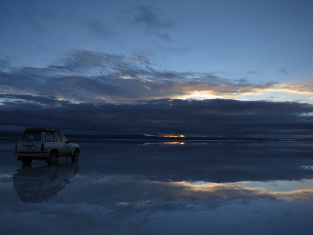 ウユニ塩湖の鏡張りの朝日（サンライズ）